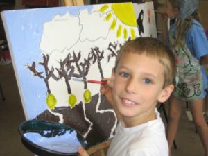 Smiling boy looks up from painting