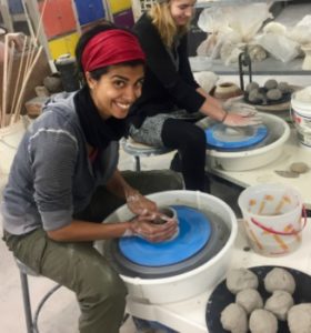 Smiling woman working at the pottery wheel at the Octagon