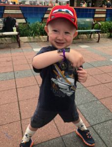 Proud child shows off the bracelet he made at the craft booth